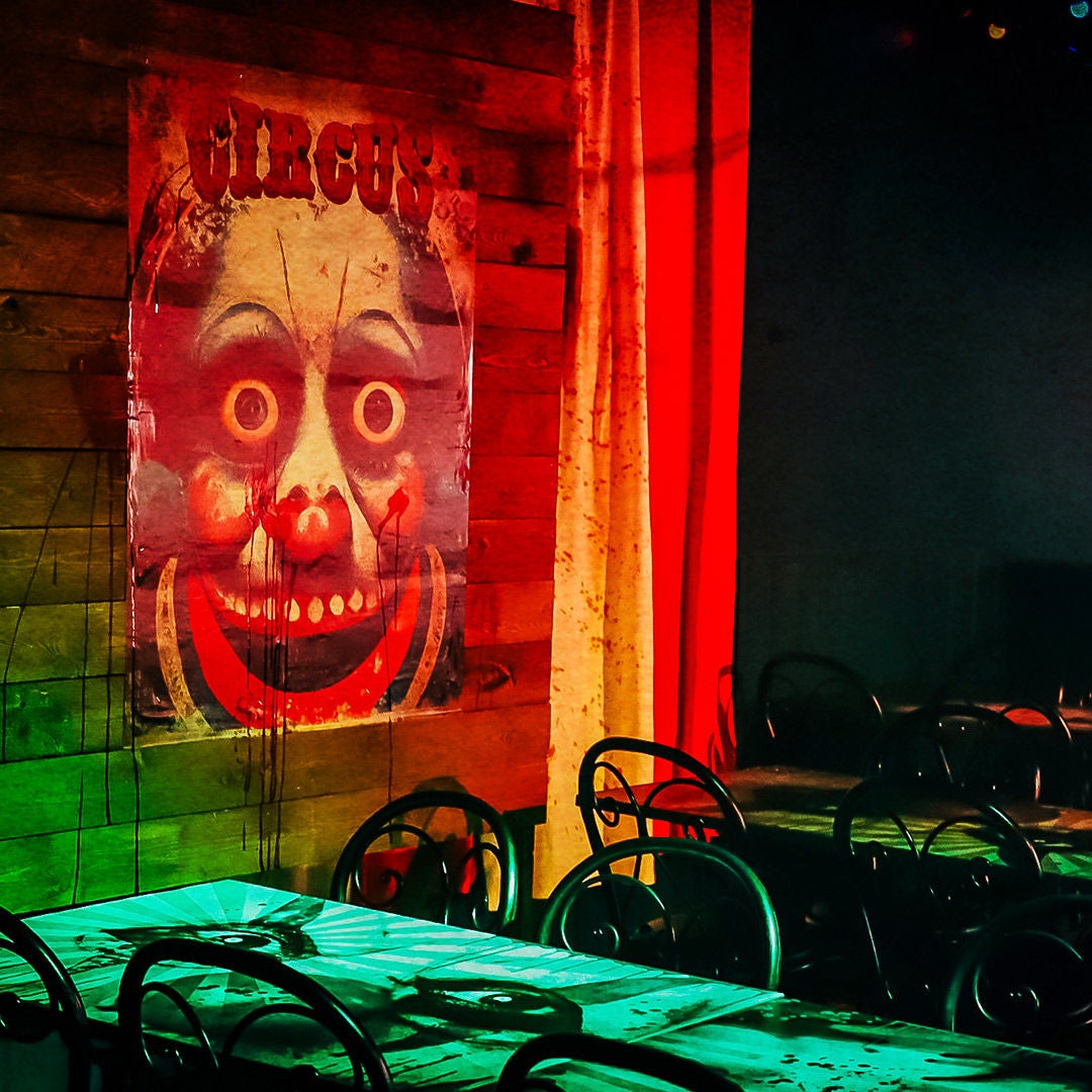 Clownposter en mysterieuze sfeer in het restaurant Freaky Pizza Festival voor het Halloween-evenement Ibilaw in Walibi Belgium