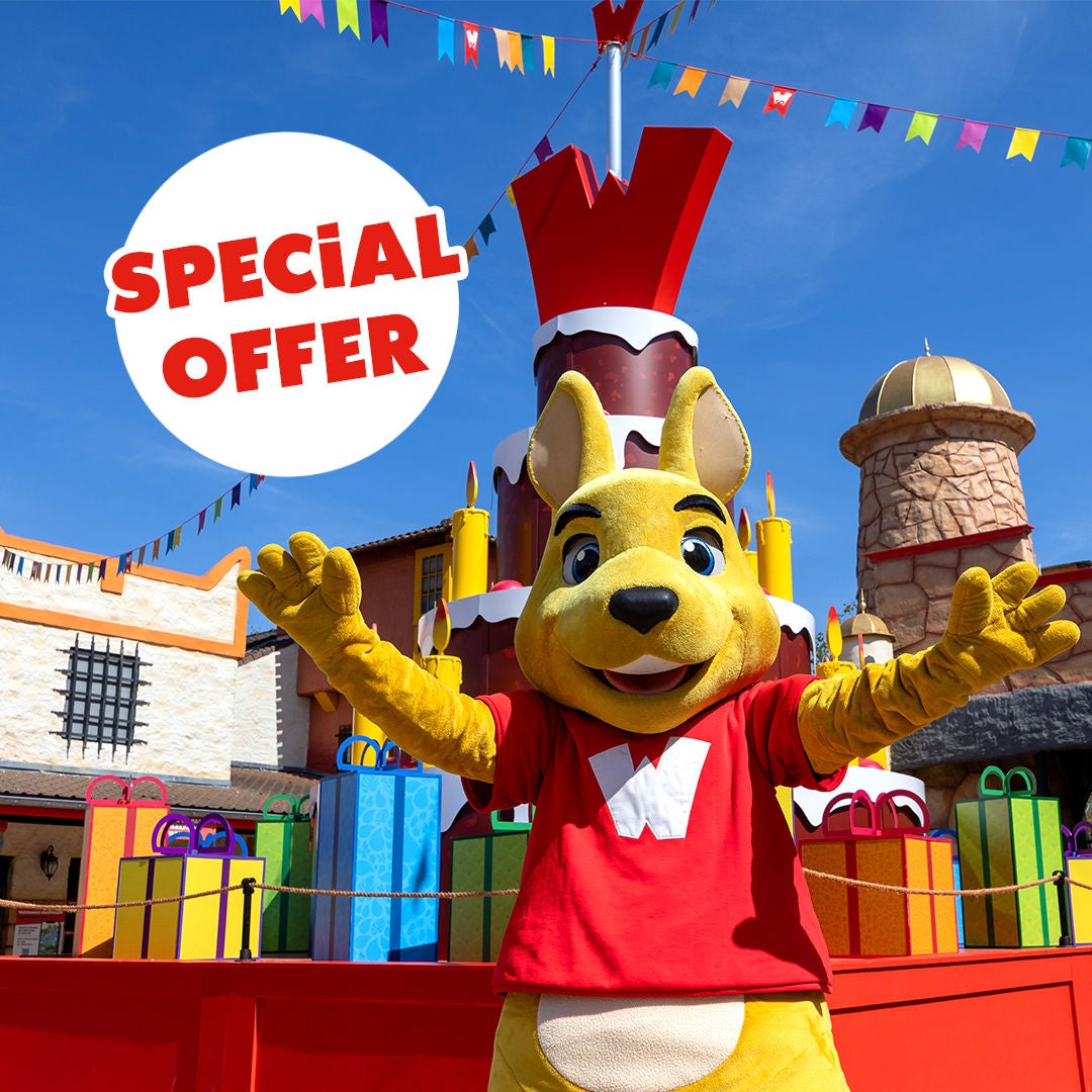 Walibi's mascot celebrates the park's birthday with a birthday cake at Walibi Belgium, highlighting the special 2+1 offer for visits from 28 July to 14 August 2026.