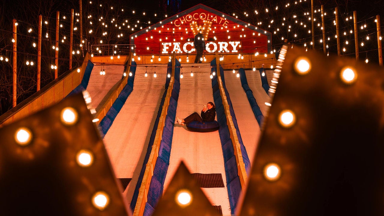 Intentiebeeld dat een Winter-activiteit bij Walibi Belgium toont: volwassenen en kinderen glijden samen van een sleehelling.